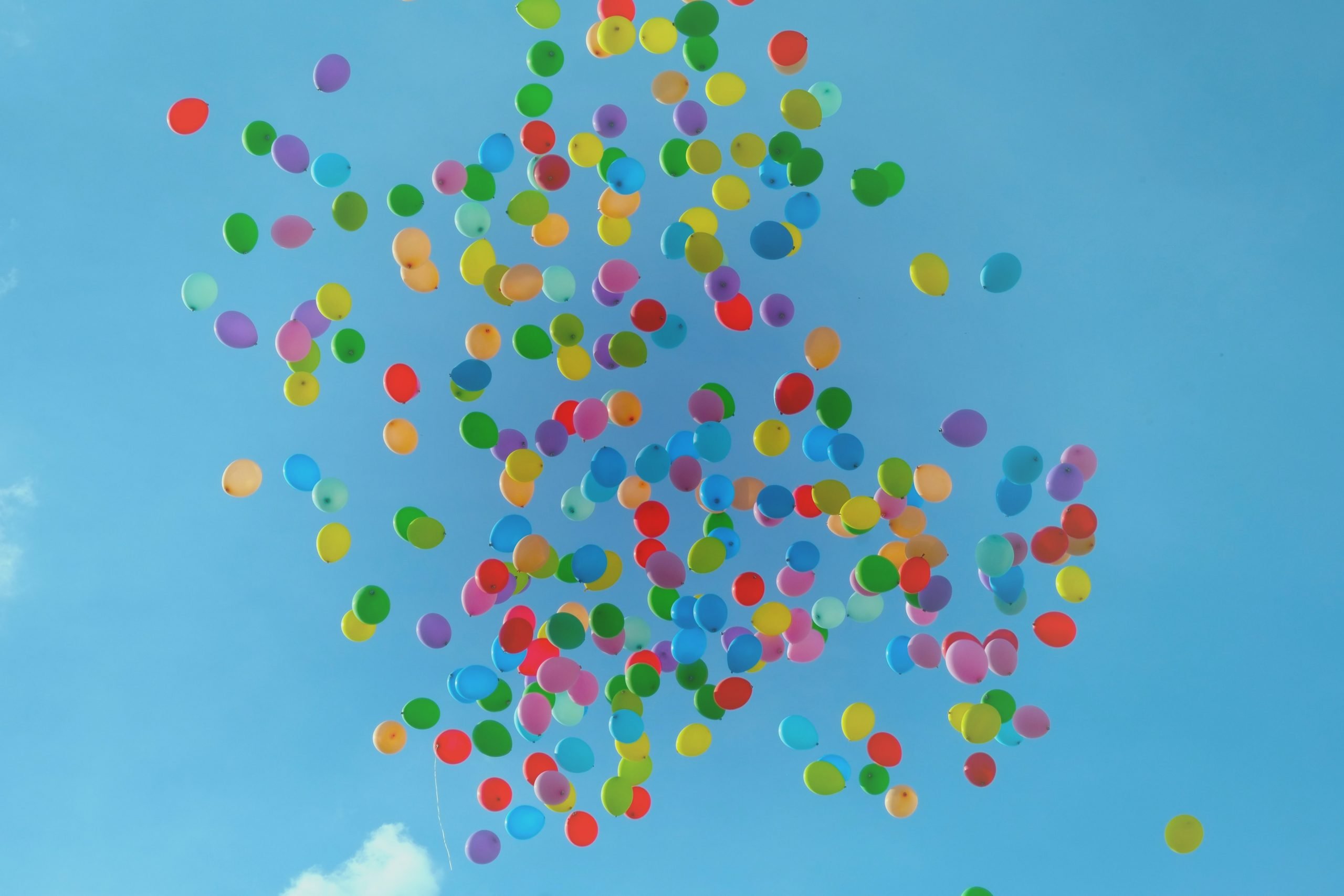 colorful balloons floating into the blue skey