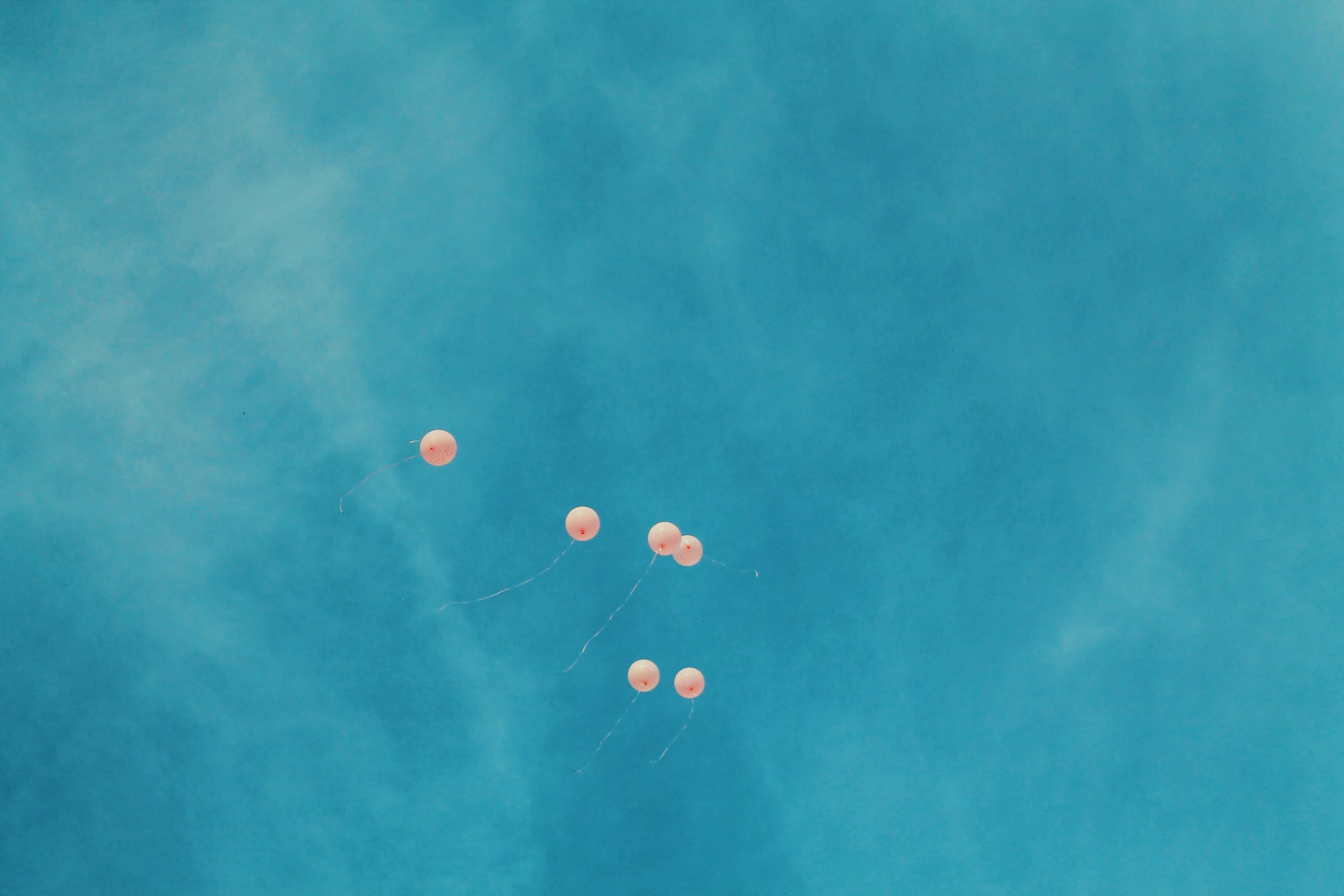 Balloons flying away in sky